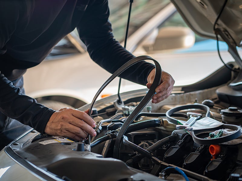 Service Person Adjusting Belt Of A Vehicle